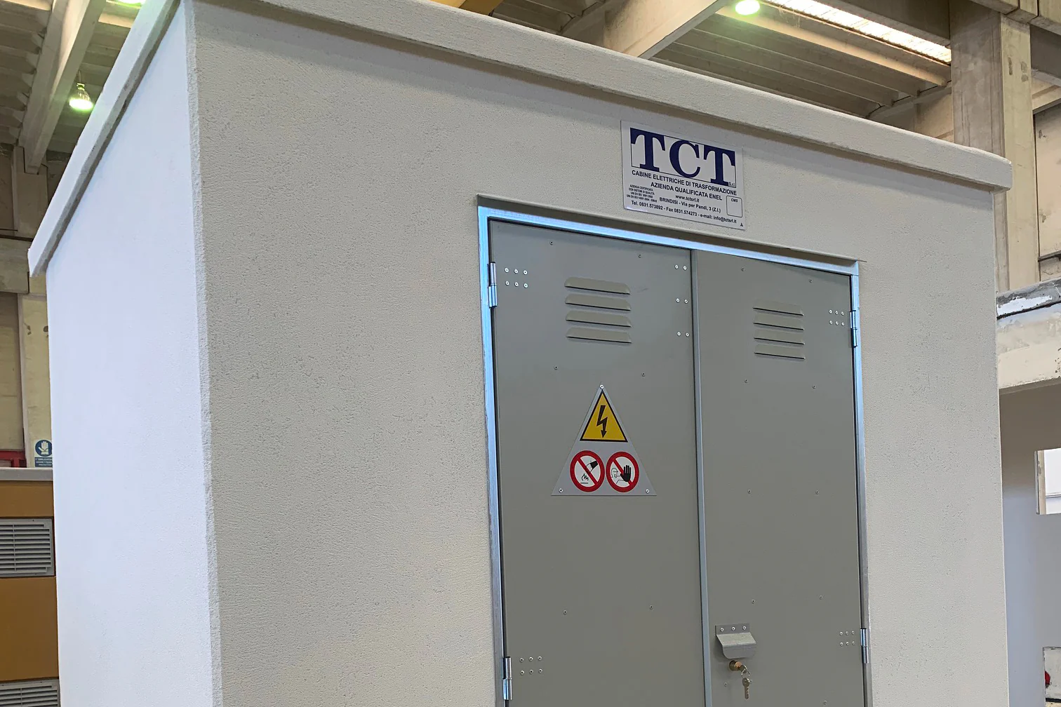 Cabina prefabbricata TCT a un vano, bianca, con la targa TCT sopra la porta